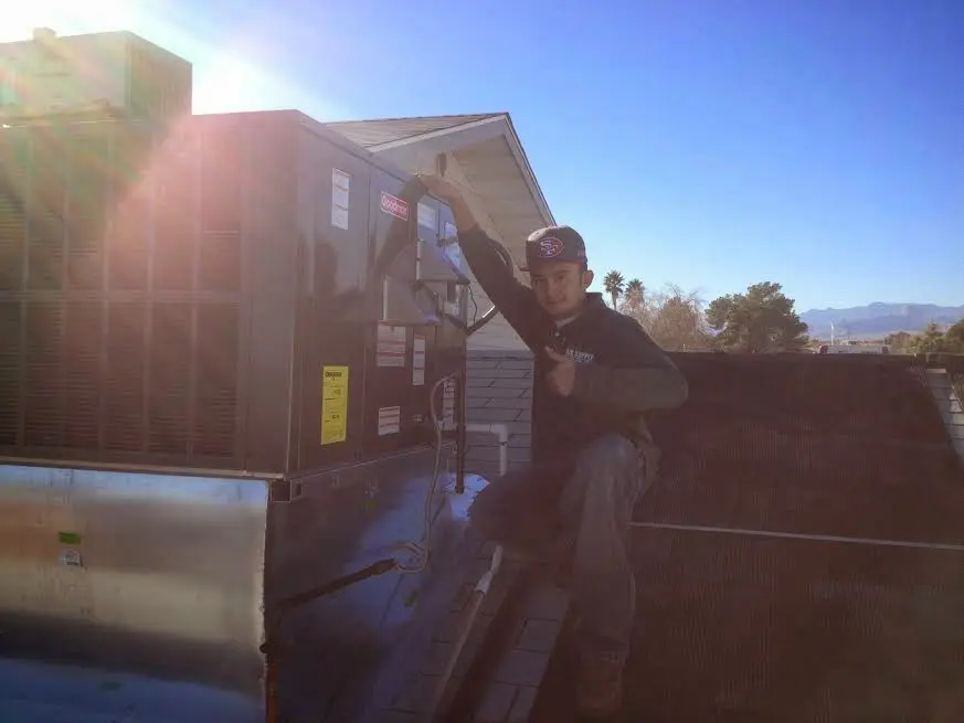 HVAC technician performing HVAC Inspection on a rooftop unit in Framingham